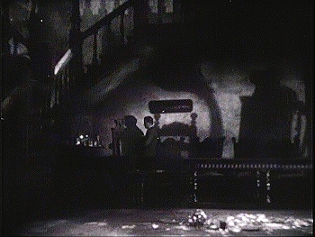 『魔の家』 1932、約58分：1階広間、食卓と影