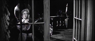 『回転』 1961　約42分：フランス窓　手前にグロース夫人の像、向こうにギデンス　右後景に二段ピラミッド