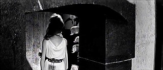 『悪徳の栄え』 1963　約1時間32分：城　吹抜歩廊への狭い湾曲階段の出口＋奥の壁に髑髏群