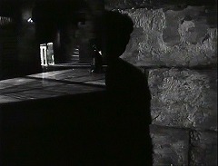 『オセロ』 1952　約1時間15分：扉の上に小アーケードのある広間の手前の壁とそこに落ちる人影